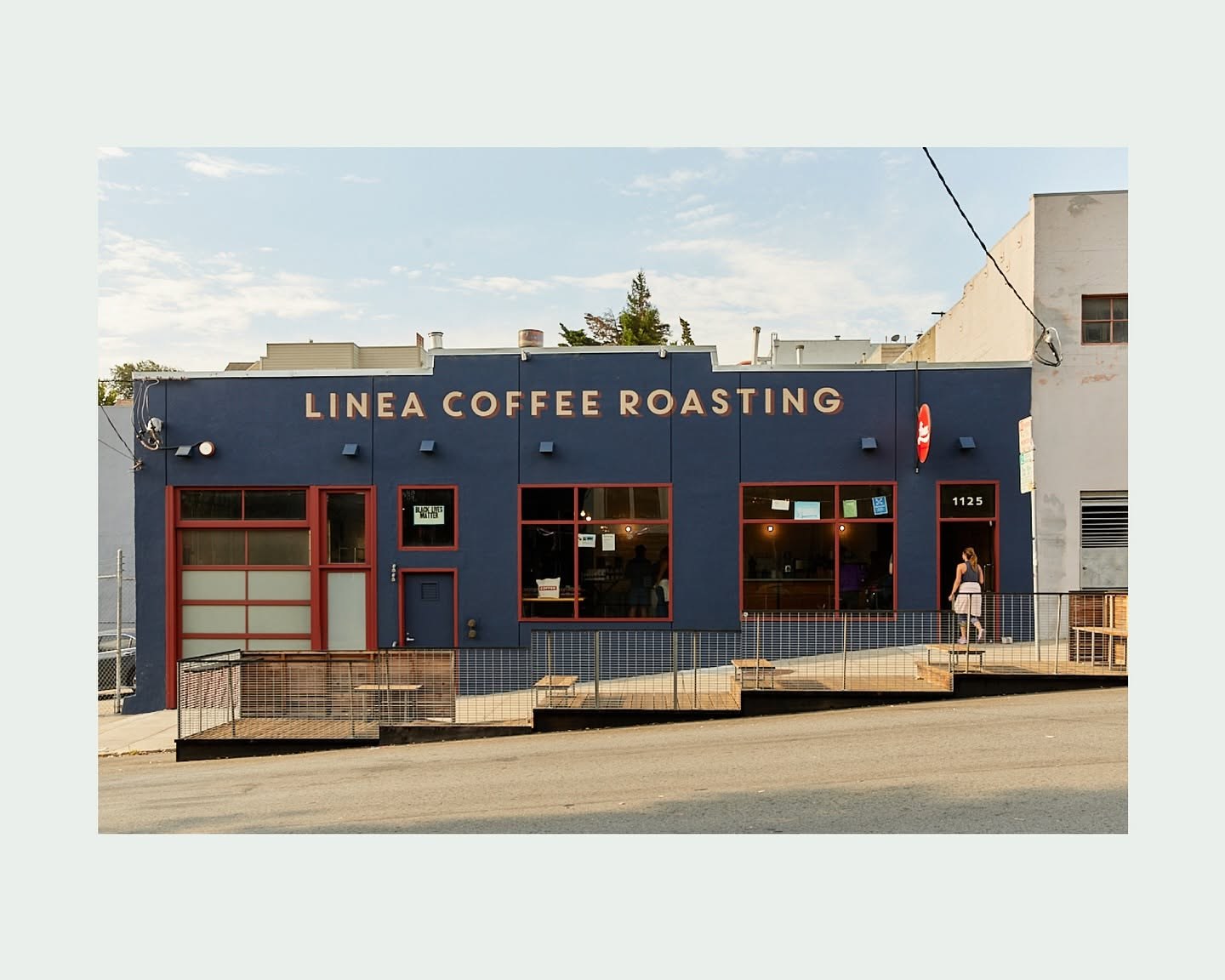 The navy storefront with Linea Coffee Roasting signage and a streetside patio